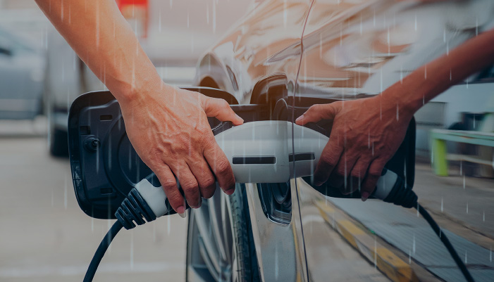 Ricaricare un'auto elettrica sotto la pioggia